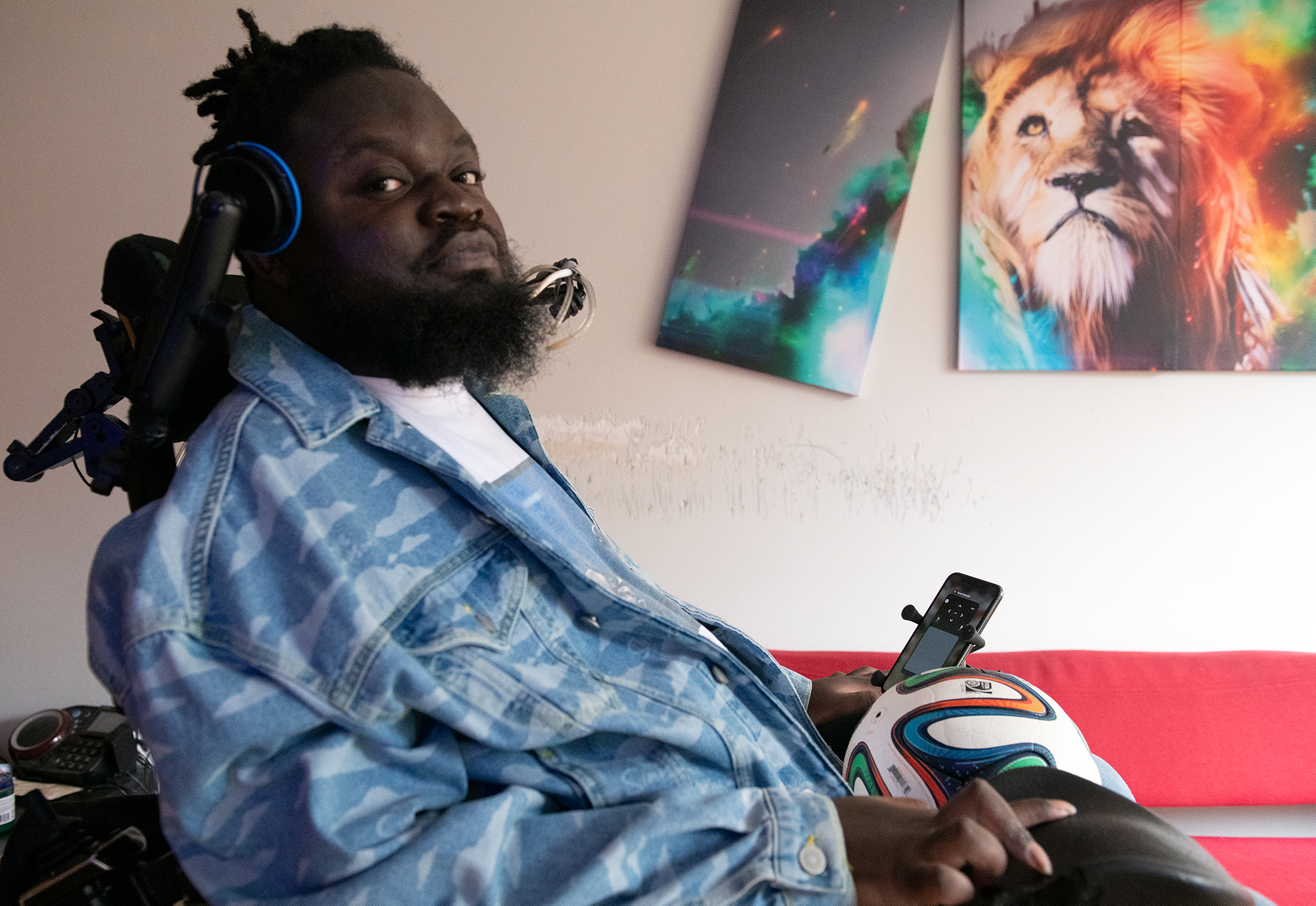 Person in electric scooter sitting in room in front of art depicting a lion. 